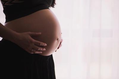 Pregnant woman in black getting prenatal chiropractic care
