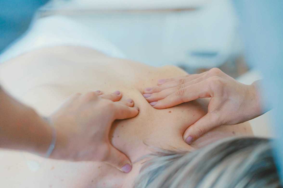 Person getting massage therapy in the upper back