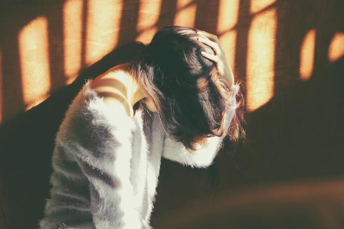 A woman in a grey sweater having a migraine headache in west kelowna