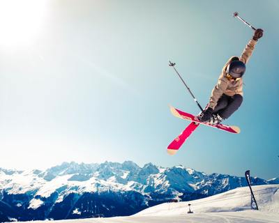 Skier performing a jump over british columbia mountain backdrop